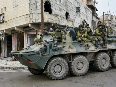 Tentara Rusia berada di kendaraan militer saat melakukan patroli dalam operasi APCs di Aleppo, Suriah. (Russian Defense Ministry Press Service photo via AP)