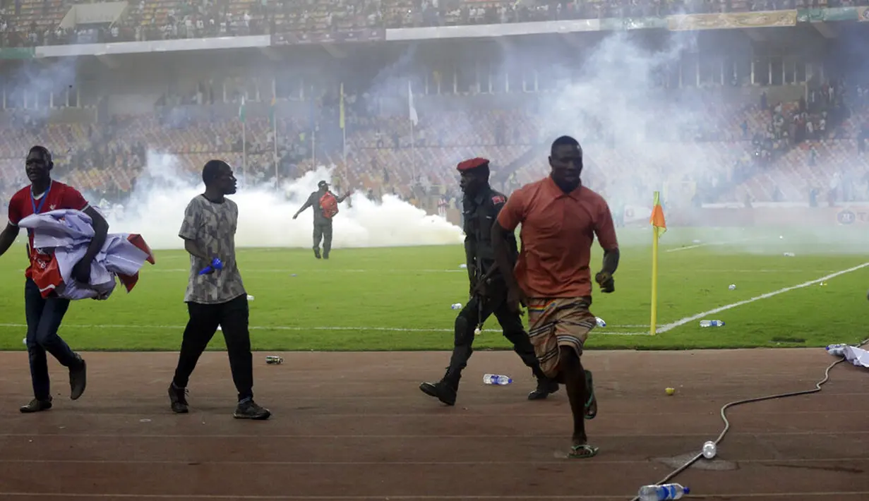 Polisi menembakkan gas air mata untuk mengejar penyerbu lapangan pada akhir pertandingan kualifikasi Piala Dunia 2022 antara Ghana Vs Nigeria di Stadion Moshood Abiola, Abuja, Nigeria, 29 Maret 2022. Fans Nigeria ngamuk setelah gagal lolos ke Piala Dunia 2022. (AP Photo/Sunday Alamba)