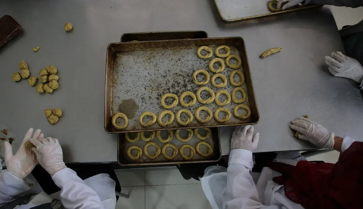 Para perempuan Palestina menyiapkan kue tradisional untuk dijual di asosiasi wanita setempat menjelang Idul Fitri untuk merayakan akhir bulan suci Ramadan di tengah karantina wilayah (lockdown) akibat epidemi COVID-19 di Kota Beit Lahia, Jalur Gaza utara, pada 17 Mei 2020. (Xinhua/Rizek Abdeljawad)