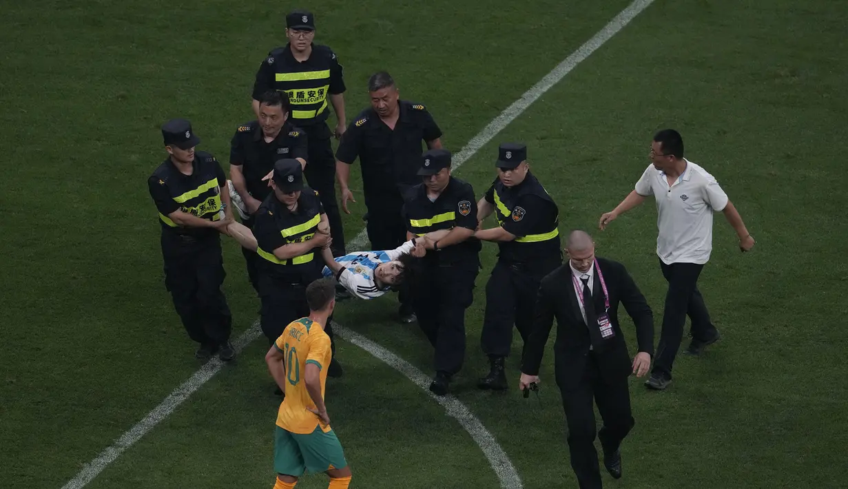 Seorang penyusup lapangan tertangkap petugas pada laga persahabatan antara Argentina melawan Australia di Workers' Stadium, Beijing, Kamis (15/06/2023). (AP Photo/Ng Han Guan)