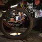 Pembuat rebana tradisional, Fajar Siddiq, yang kehilangan pekerjaan karena pandemi Covid-19, bekerja di rumahnya di Lambaro, Provinsi Aceh, Senin (22/2/2021). Usaha produksi berbagai jenis alat musik tradisional Aceh berupa rapai, serune kale dan seruling mulai langka. (CHAIDEER MAHYUDDIN / AFP)