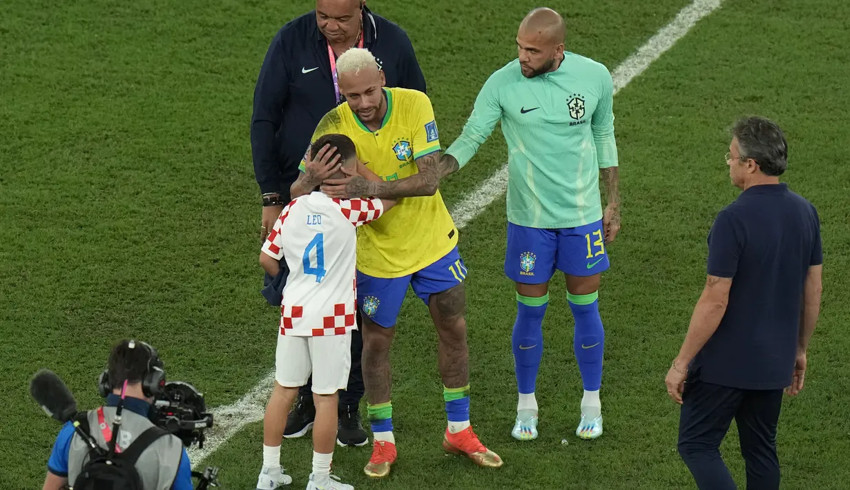 Penyerang Brasil #10 Neymar memeluk putra gelandang Kroasia #04 Ivan Perisic setelah kalah pada perempat final Piala Dunia 2022 di Stadion Education City, Sabtu (10/12/2022) dini hari WIB. Tangis Neymar membuat anak-anak bintang Kroasia Ivan Perisic menghampiri bintang Paris Saint-Germain tersebut. (AP Photo/Alessandra Tarantino)