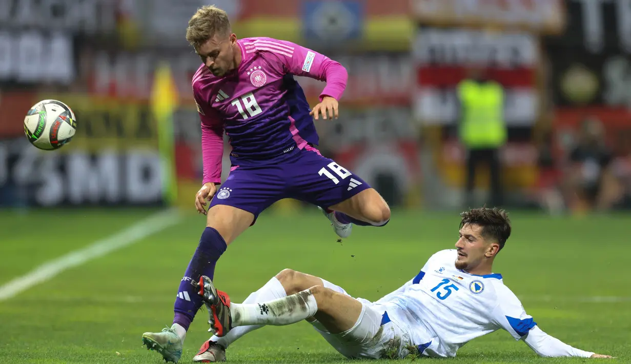 Pemain Bosnia-Herzegovina, Armin Gigovic (bawah) mencoba menahan laju Maximilian Mittelstadt (Jerman) matchday 3 Grup C UEFA Nations League A 2024/2025 di Bilino Polje Stadium, pada Jumat 11 Oktober 2024 atau Sabtu 12 Oktober 2024 dini hari WIB. (AP Photo/Armin Durgut)