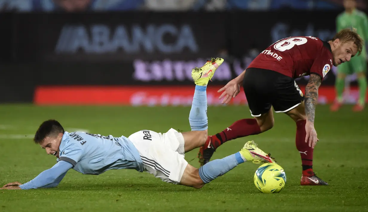 Pemain Celta Vigo Franco Cervi (kiri) berebut bola dengan pemain Valencia Daniel Wass pada pertandingan Liga Spanyol di Stadion Balaidos, Vigo, Spanyol, 5 Desember 2021. Valencia menang 2-1. (MIGUEL RIOPA/AFP)
