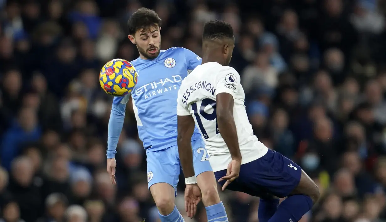 Gelandang Manchester City Bernardo Silva berebut bola dengan gelandang Tottenham Hotspur Ryan Sessegnon pada pekan ke-26 Liga Inggris di Etihad stadium, Minggu (20/2/2022) dinihari WIB. Manchester City takluk 2-3 dari tim tamu, Tottenham Hotspur.  (AP Photo/Jon Super)