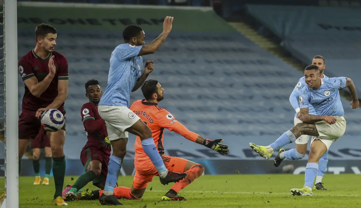 Striker Manchester City, Gabriel Jesus (kanan) melepaskan tendangan yang berbuah gol kedua timnya ke gawang Wolverhampton Wanderers dalam laga lanjutan Liga Inggris 2020/21 pekan ke-27 di Etihad Stadium, Selasa (2/3/2021). Manchester City menang 4-1 atas Wolverhampton. (AP/Carl Recine/Pool)