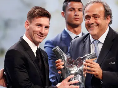 Lionel Messi menerima piala penghargaan sebagai pemain terbaik Eropa 2014-2015 dari Presiden UEFA Michel Platini di Monte Carlo, Kamis (27/8/2015). Pemain Argentina ini menyisihkan Cristiano Ronaldo dan Luis Suarez. (REUTERS/Eric Gaillard)