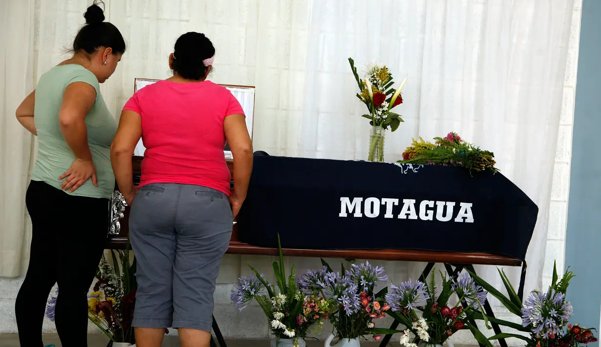Keluarga korban kericuhan pertandingan sepak bola berdiri di dekat peti mati Jose Vidal Zuniga di kota Tegucigalpa, Honduras (29/5). Pertandingan tersebut berjalan ricuh sehingga mengakibatkan empat orang meregang nyawa. (AP Photo/Fernando Antonio)