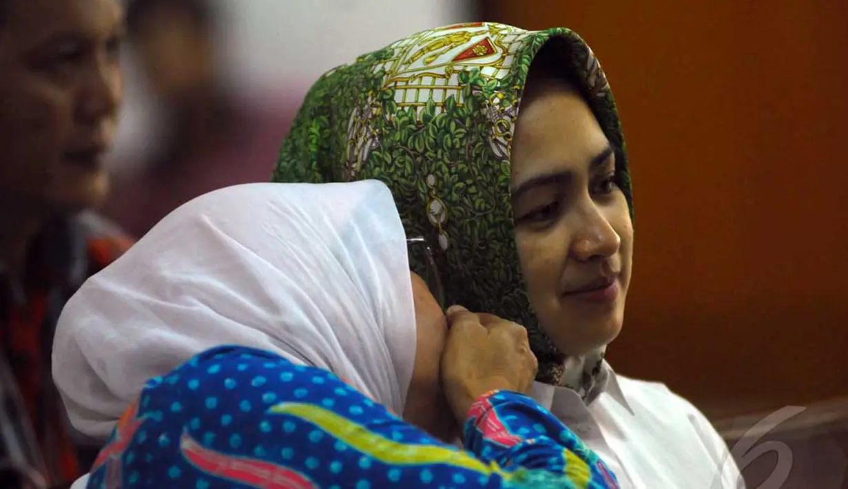 Airin yang mengenakan kemeja putih dibalut kerudung warna hijau bermotif itu tampak duduk di bangku pengunjung. Seorang wanita disampingnya terlihat berbisik pada Airin di Pengadilan Tipikor Jakarta, Senin (9/6/2014) (Liputan6.com/Miftahul Hayat)