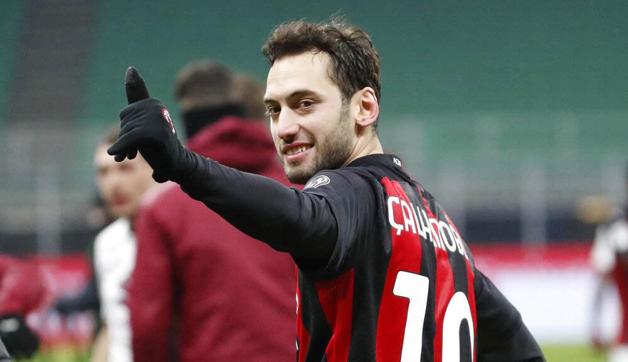 Pemain AC Milan, Hakan Calhanoglu, merayakan kemenangan atas Torino pada laga Coppa Italia di Stadion San Siro, Selasa (12/1/2021). AC Milan menang adu penalti dengan skor 5-4. (AP/Antonio Calanni)