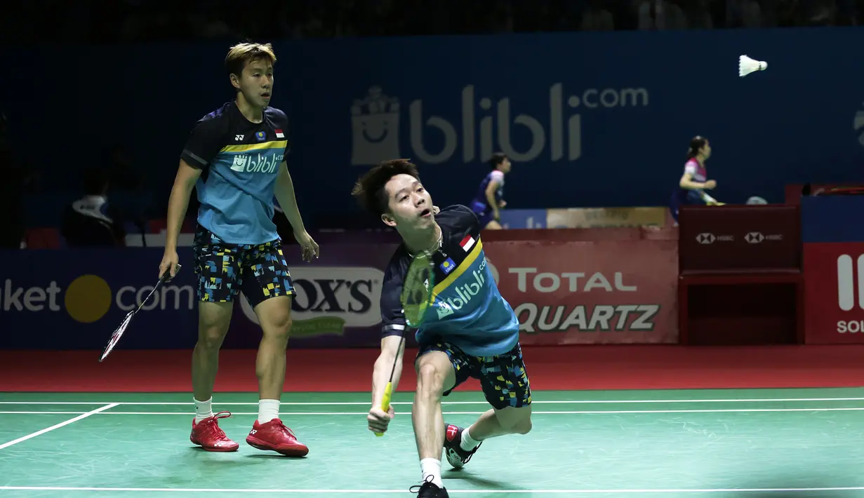 Ganda putra Indonesia, Marcus Gideon / Kevin Sanjaya, mengembalikan kok saat melawan Ou Xuan Yi / Zhang Nan pada Indonesia Open 2019 di Istora Senayan, Jumat (19/7). Marcus / Kevin menang 21-12 dan 21-16. (Bola.com/Yoppy Renato)