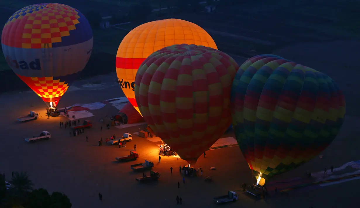 Sejumlah balon udara panas melakukan persiapan sebelum terbang membawa wisatawan di Luxor, Kairo, Mesir (13/12). Di kota Luxor, beberapa situs-situs kuno masih berdiri kokoh. (Reuters/Amr Abdallah Dalsh)