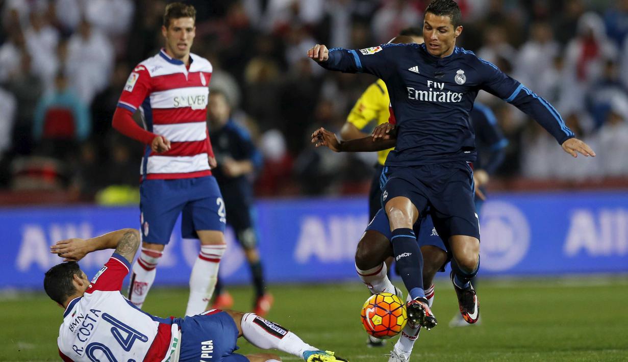 Pemain Real Madrid, Cristiano Ronaldo (kanan) mencoba melewati hadangan para pemain Granada pada lanjutan La Liga Spanyol di di Estadio Nuevo Los Carmenes, Senin (8/2/2016) dini hari WIB. (REUTERS/Marcelo del Pozo)