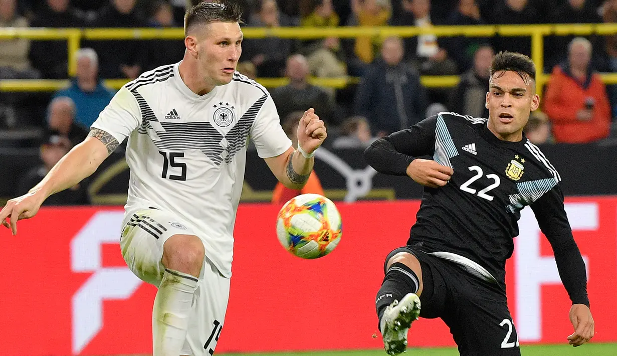 Bek timnas Jerman, Niklas Sule berebut bola dengan pemain Timnas Argentina Lautaro Martinez dalam laga persahabatan di Stadion Signal Iduna Park, Dortmund, Rabu (9/10/2019).  Sempat unggul dua gol, Timnas Jerman harus puas bermain 2-2 setelah Argentina mampu menyamakan kedudukan (AP/Martin Meissner)