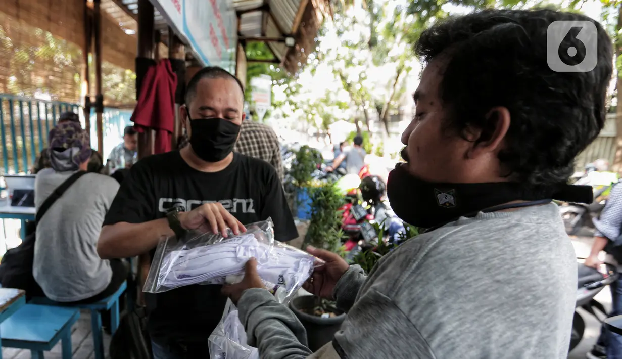 Anggota Pewarta Foto Indonesia Jakarta (PFIJ) menerima paket penunjang liputan di Jakarta, Rabu (22/4/2020). PFIJ membagikan 230 paket penunjang liputan berupa masker, hand sanitizer, dan multivitamin kepada anggotanya yang melaksanakan tugas jurnalistik selama pandemi. (Liputan6.com/Johan Tallo)