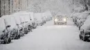 Sebuah mobil melintas saat hujan salju turun di Munich, Jerman selatan, (18/4). Hujan salju yang melanda kawasan ini tidak menyurutkan warga untuk tetap beraktivitas. (AFP PHOTO / dpa / Tobias Hase / Jerman OUT)