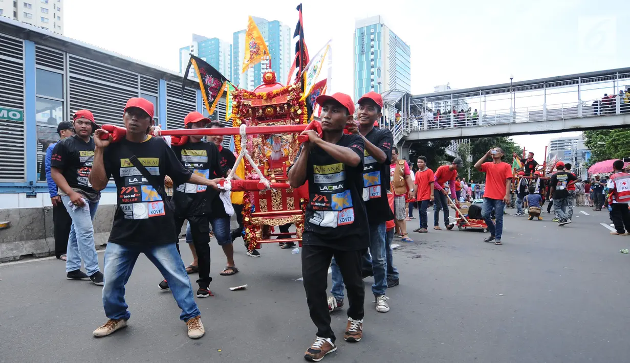 Iring-iringan patung dewa melintasi di Jalan Gajah Mada, Jakarta, Minggu (4/3). Beragam atraksi budaya yang ada di Indonesia ditampilkan dalam karnaval perayaan Cap Go Meh 2018 di kawasan Glodok Jakarta. (Liputan6.com/Helmi Fithriansyah)