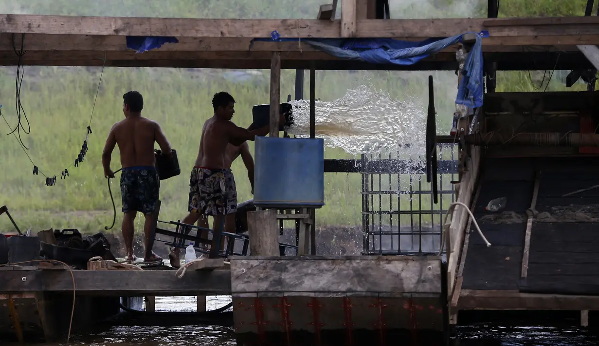Penambang emas ilegal memadamkan api yang membakar tongkang di Sungai Madeira, Borba, Amazonas, Brasil, 28 November 2021. Institut Lingkungan dan Sumber Daya Alam Terbarukan Brasil membakar lebih dari 60 tongkang untuk menahan penambangan emas ilegal di anak Sungai Amazon. (AP Photo/Edmar Barros)