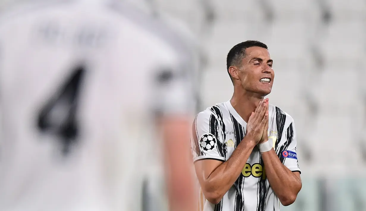 Penyerang Juventus, Cristiano Ronaldo, tampak kecewa usai kalah agregat oleh Olympique Lyon dan tersingkir dari Liga Champions 2019/2020 di Stadion Allianz, Sabtu (8/8/2020) dini hari WIB. Juventus kalah agregat 2-2 atas Olympique Lyon. (AFP/Miguel Medina)