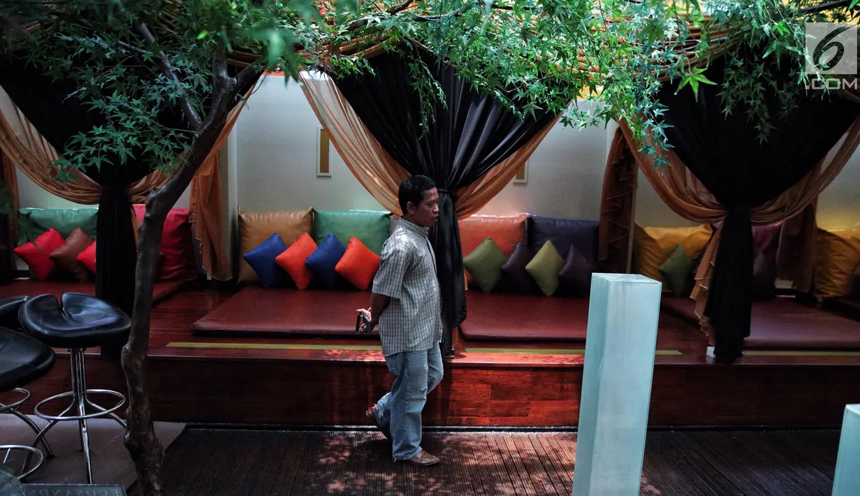 Seorang pria melintas di depan gazebo dengan penutup di lantai tujuh Hotel Alexis, Jakarta, Selasa (31/10). Gazebo panjang itu bisa dipisahkan dengan tirai-tirai dan dilengkapi matras dan aneka bantal warna-warni. (Liputan6.com/Faizal Fanani)