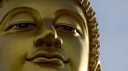 Patung Buddha raksasa setinggi 69 meter berdiri di kuil Wat Paknam Phasi Charoen di pinggiran Bangkok, Thailand pada Selasa (12/10/2021). Dana pembangunan patung diperoleh dari sumbangan 500 juta baht atau setara 228 miliar rupiah. (Jack TAYLOR / AFP)