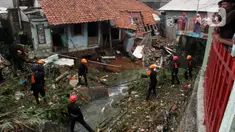 Tim SAR gabungan dari Brimob Kedung Halang dan relawan membersihkan material longsor yang terjadi akibat luapan Kali Cibuluh semalam di Cibuluh, Kedung Halang, Bogor, Jawa Barat, Kamis (30/11/2023). Hujan deras yang melanda Kota Bogor tadi malam menyebabkan banjir dan tanah longsor di beberapa lokasi. (merdeka.com/Arie Basuki)