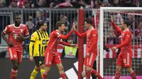 Bintang Bayern Munchen, Thomas Muller disambut rekannya Benjamin Pavard usai mencetak gol ke gawang Borussia Dortmund, Minggu (2/4/2023) dini hari WIB. (AP Photo/Matthias Schrader)