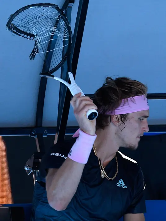 Petenis Jerman, Alexander Zverev merusak raketnya saat beristirahat pada putaran keempat Australia Terbuka  menghadapi petenis Kanada, Milos Raonic di Melbourne, Senin (21/1). Zverev frustasi setelah kalah dua set 6-1 4-1. (AP/Andy Brownbill)