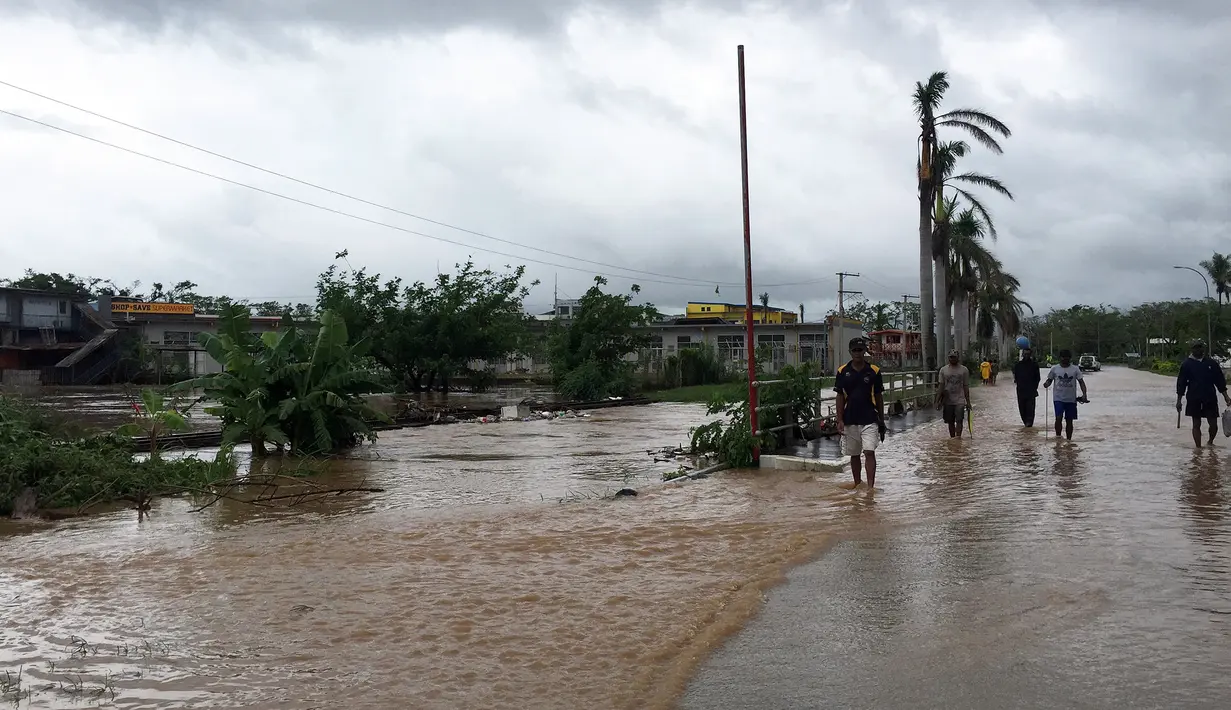 Warga berjalan melewati banjir di kota Ba, wilayah barat Fiji, Rabu (6/4). Momen kedatangan badai tropis kategori tiga, Zena itu didahului dengan hujan deras. (NAZIAH ALI/MAI LIFE MAGAZINE /AFP)