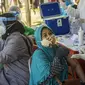 Warga menerima vaksin virus corona COVID-19 Sinovac di klinik vaksinasi massal darurat di lapangan sepak bola di Surabaya, Jawa Timur, Selasa (6/7/2021). Indonesia tengah memerangi gelombang infeksi baru yang belum pernah terjadi sebelumnya. (JUNI KRISWANTO/AFP)