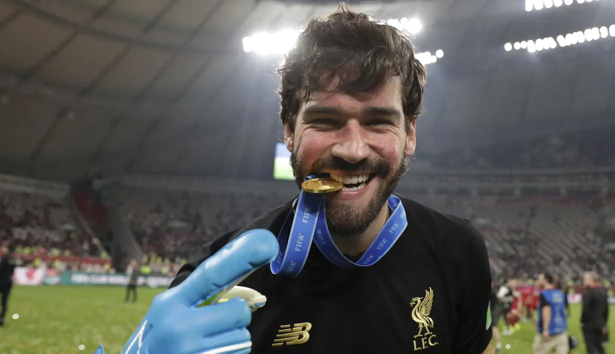 Kiper Liverpool, Alisson mengigit medali usai pertandingan melawan Flamengo pada final Piala Dunia Antarklub 2019 di Stadion Internasional Khalifa di Doha, Qatar (22/12/2019). Liverpool menang 1-0 atas Flamengo berkat gol tunggal Roberto Firmino di menit ke-99. (AP Photo/Hassan Ammar)
