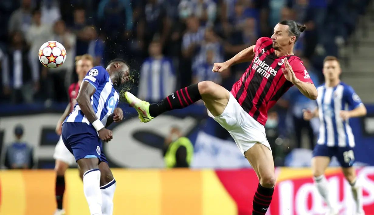 Pemain AC Milan Zlatan Ibrahimovic berebut bola dengan pemain Porto Chancel Mbemba (kiri) pada pertandingan sepak bola Grup B Liga Champions di Stadion Dragao, Porto, Portugal, Selasa (19/10/2021). Porto menang 1-0. (AP Photo/Luis Vieira)