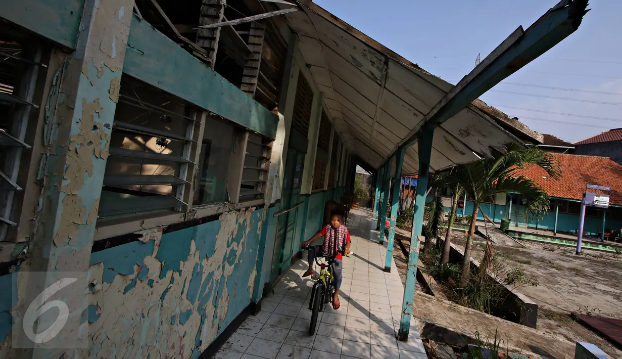 Seorang anak melintas di antara ruang kelas yang rusak di SDN Klender 15, Jakarta Timur, Rabu (18/11). 293 siswa SDN Klender 15 terpaksa mengungsi belajar di SDN Klender 14. (Liputan6.com/Immanuel Antonius)
