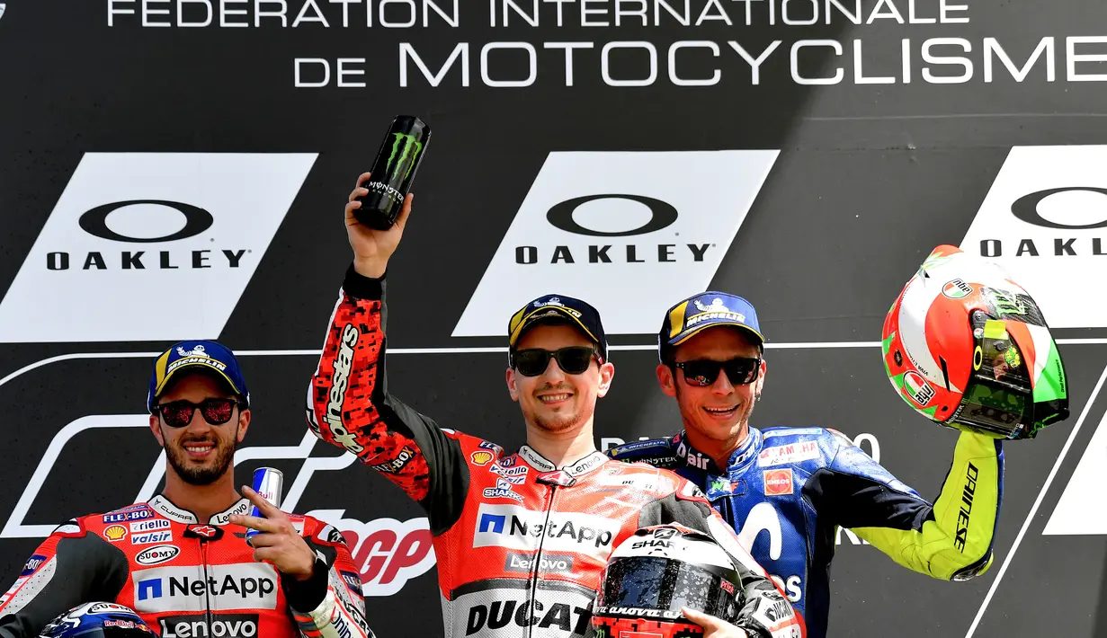 Pembalap Ducati Team, Jorge Lorenzo (tengah) berpose di podium dengan pembalap Italia Movistar Yamaha, Valentino Rossi dan Ducati Team, Andrea Dovizioso usai balapan Moto Grand Prix di Sirkuit Mugello, Italia, Minggu (03/6). (AFP FOTO / Tiziana Fabi)