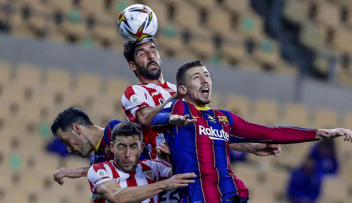 Pemain Athletic Bilbao, Raul Garcia, duel udara dengan pemain Barcelona, Clement Lenglet, pada laga final Piala Super Spanyol di Stadion La Cartuja, Minggu (17/1/2021). Athletic Bilbao menang 3-2 atas Barcelona. (AP/Miguel Morenatti)