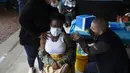 Seorang perempuan muda disuntik vaksin COVID-19 di sebuah lokasi dekat Johannesburg, Rabu (8/12/2021). Kasus Omicron telah dikonfirmasi setidaknya di sembilan negara Afrika, dengan Afrika Selatan tetap menjadi episenter awal ditemukannya varian baru tersebut. (AP Photo/Denis Farrell)
