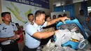 Salah satu anggota TNI AU memeriksa  barang yang diduga milik penumpang pesawat AirAsia QZ8501, Pangkalan Bun, Kalteng, Selasa (30/12/2014). (Liputan6.com/Miftahul Hayat)