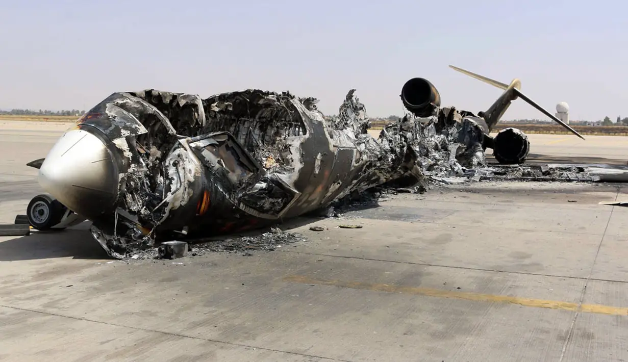 Sisa reruntuhan sebuah pesawat terlihat di Bandara Internasional Tripoli, Libya, (21/7/2014). (REUTERS/Hani Amara)