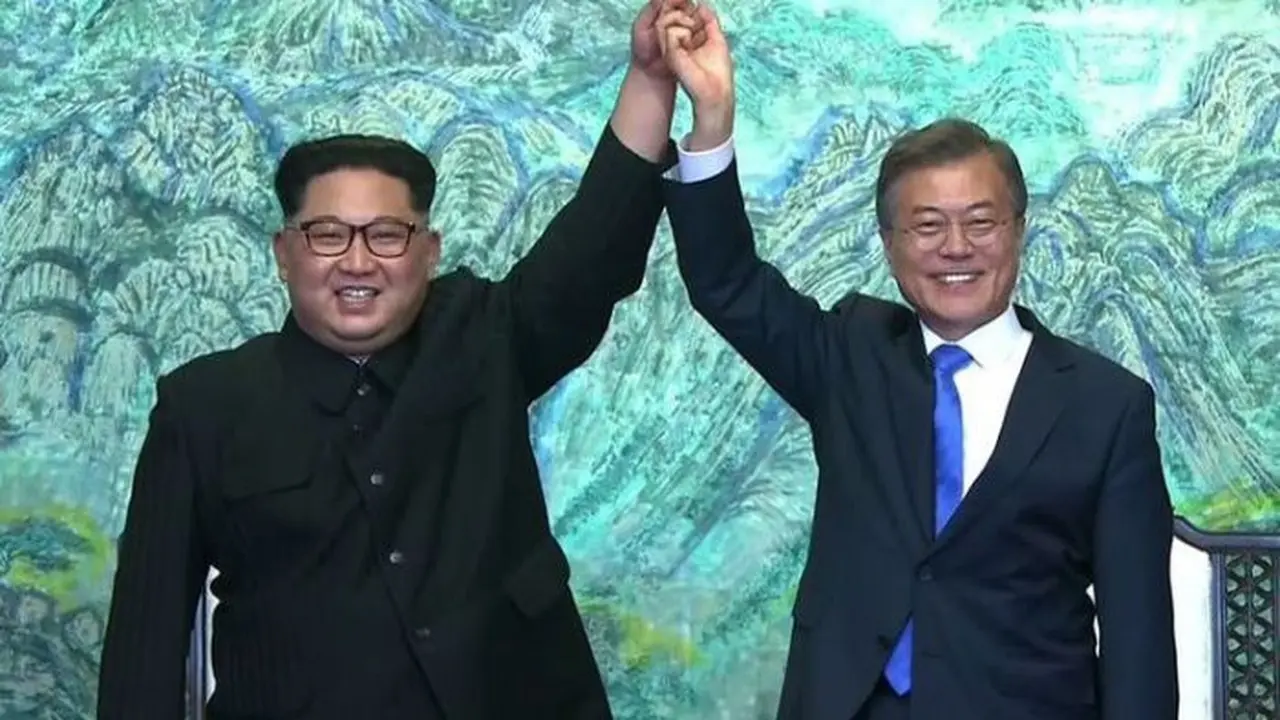 Pemimpin Korea Utara Kim Jong Un (kiri), dan Presiden Korea Selatan Moon Jae In berpegangan tangan dalam Konferensi Tingkat Tinggi (KTT) Antar-Korea di Panmunjom. (AFP/Arsip)