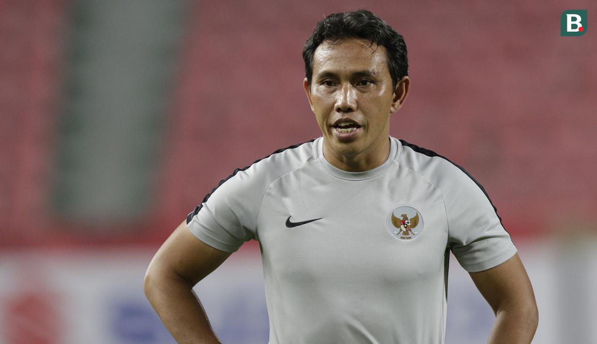 Pelatih Timnas Indonesia, Bima Sakti, memberikan instruksi saat latihan di Stadion Rajamangala, Bangkok, Jumat, (16/11). Latihan ini persiapan jelang laga Piala AFF 2018 melawan Thailand. (Bola.com/M. Iqbal Ichsan)