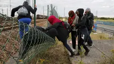 Sejumlah imigran gelap berusaha melewati pagar keamanan terminal Eurotunnel di Coquelles dekat Calais di Prancis, 29 Juli 2015. Ribuan imigran tersebut mencoba memasuki Terowongan Channel menuju Inggris melalui Prancis. (REUTERS/Pascal Rossignol)