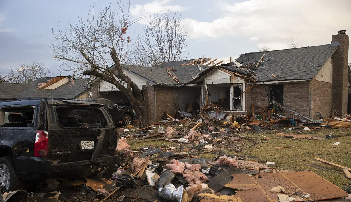 Puing-puing berserakan di luar sebuah rumah yang rusak parah akibat tornado di Oxford Drive di Round Rock, Texas, Senin (21/3/2022). (Jay Janner/Austin American-Statesman via AP)