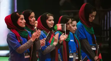 Tim perempuan dari Afghanistan mengikuti upacara pembukaan lomba robotik di Washington, AS, Minggu (16/7). Setelah sempat ditolak dua kali, akhirnya mereka memperoleh izin visa untuk terbang ke Negeri Paman Sam. (AP/Cliff Owen)