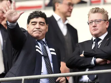 Diego Maradona melambaikan tangan kepada fans saat menyaksikan laga Totenham Hotspur melawan Liverpool di Wembley Stadium, London, (22/10/2017). (Adam DavyPA via AP)