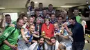 Kanselir Jerman, Angela Merkel (tengah), saat merayakan gelar juara dunia 2014 bersama para pemain di ruang ganti di Stadion Maracana, Rio de Janeiro, Brasil, (13/7/2014). (AFP PHOTO/Bundesregierung/Guido Bergmann) 