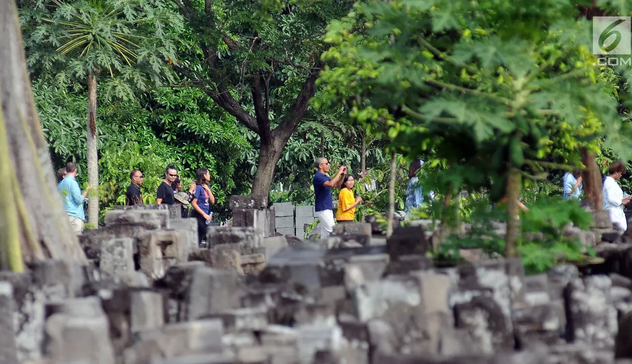 Mantan Presiden Amerika Serikat, Barack Obama memotret saat memasuki kawasan Candi Prambanan, Yogyakarta, Kamis (29/6). Barack Obama beserta keluarga berlibur dan mengunjungi sejumlah tempat di Yogyakarta. (Liputan6.com/Helmi Fithriansyah)