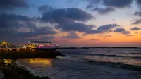 Pemandangan di sekitar restoran berbentuk perahu di tepi pantai Kota Gaza, Jalur Gaza, Palestina, Rabu (2/8). Restoran yang berada di atas batu karang tersebut menyuguhkan indahnya langit dengan gradasi warna biru dan oranye. (MOHAMMED ABED / AFP)