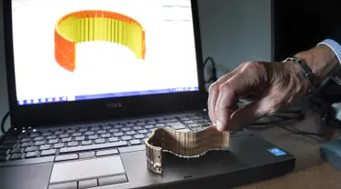 Seorang pekerja Comite Franceclat memperlihatkan gelang emas hasil mesin cetak 3D di Besancon, Prancis, 11 Oktober 2017. Mesin cetak 3D kini mulai merambah ke dunia desain perhiasan. (AFP FOTO / SEBASTIEN BOZON)