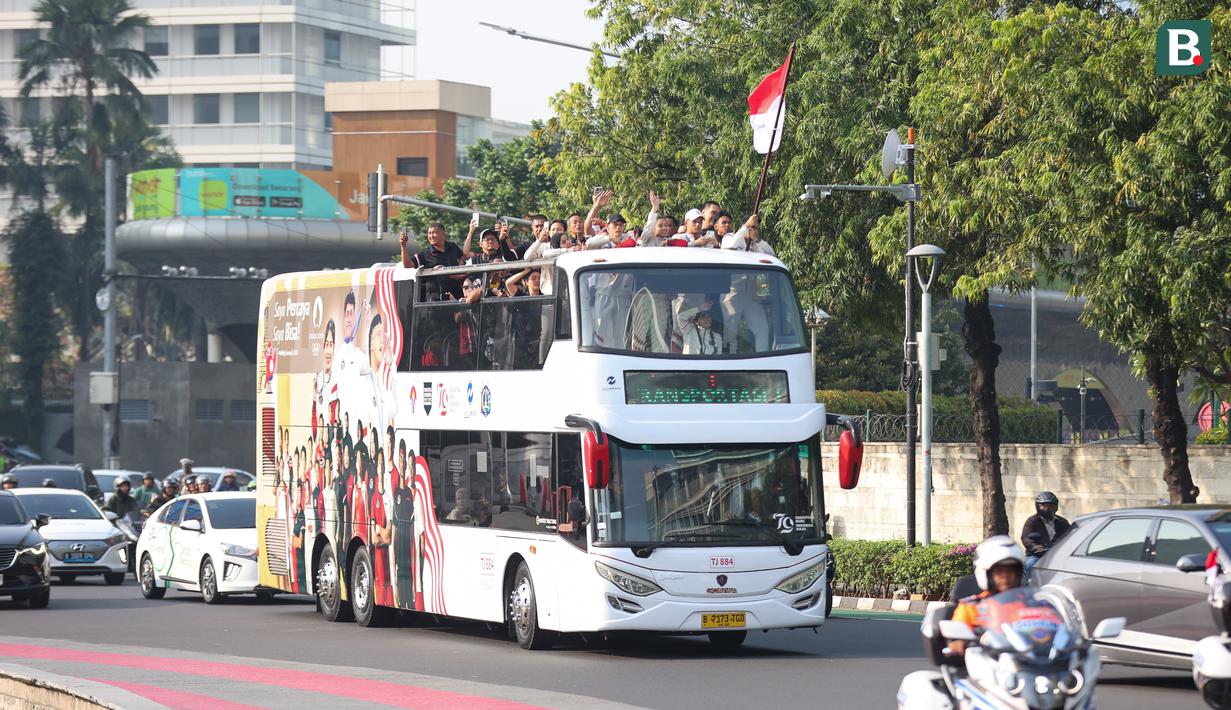 Sejumlah atlet dan ofisial Kontingen Indonesia pada Olimpiade Paris 2024, termasuk peraih medali emas, Veddriq Leonardo dan Rizki Juniansyah serta peraih medali perunggu, Gregoria Mariska Tunjung mengikuti pawai dengan menaiki bus tingkat terbuka Transjakarta menuju Istana Negara, Jakarta Pusat, Kamis (15/8/2024). (Bola.com/Abdul Aziz)