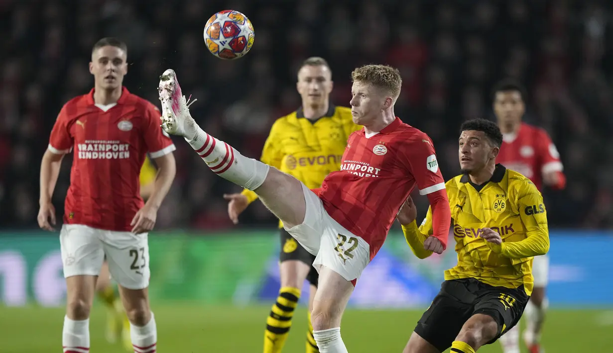 Pemain PSV, Jerdy Schouten (tengah) mengontrol bola dibayangi pemain Borussia Dortmund, Jadon Sancho pada laga leg pertama 16 besar Liga Champions 2023/2024 di The Philips Stadium, Eindhoven, Belanda, Rabu (21/02/2024) dini hari WIB. (AP Photo/Peter Dejong)